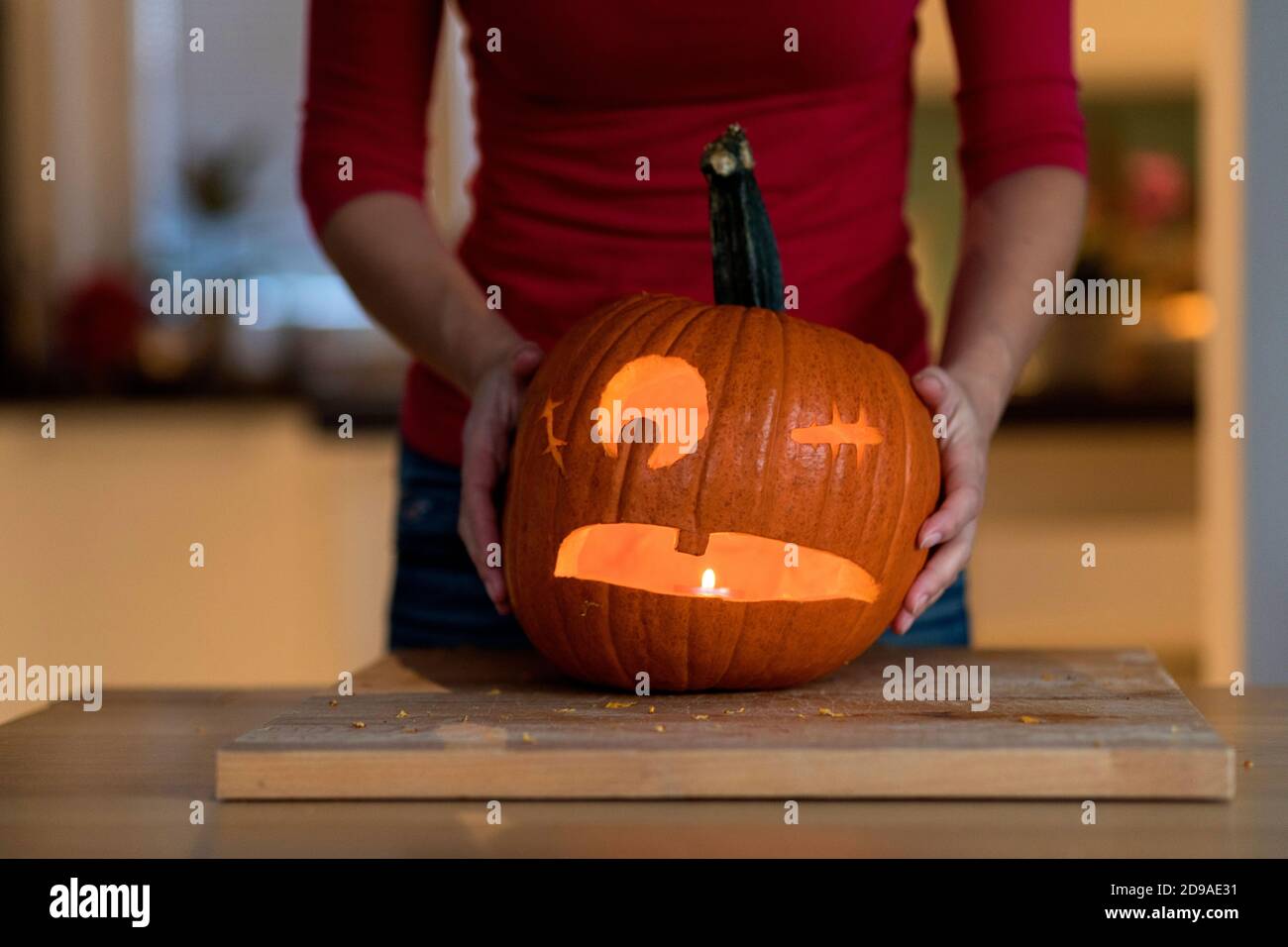 Une femme a sculpté la citrouille d'Halloween et y a inséré une bougie Banque D'Images
