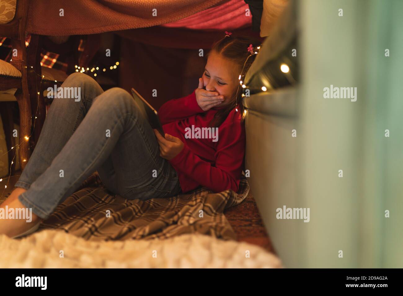 Fille caucasienne riant et utilisant un ordinateur de tablette Banque D'Images