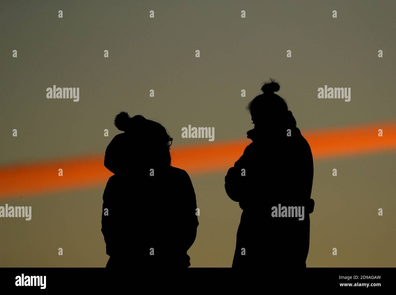 Newtown Linford, Leicestershire, Royaume-Uni. 4 novembre 2020. Météo au Royaume-Uni. Les femmes regardent le lever du soleil depuis Old John dans Bradgate Park. Credit Darren Staples/Alay Live News. Banque D'Images