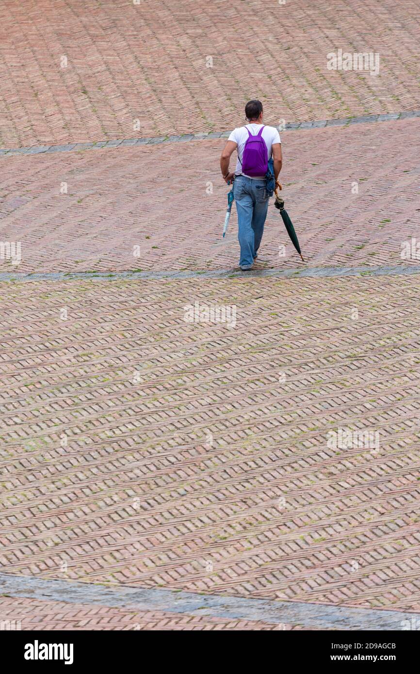 Un homme avec son dos s'est penché sur un parapluie dans la Piazza del Campo, Sienne, Toscane, Italie Banque D'Images