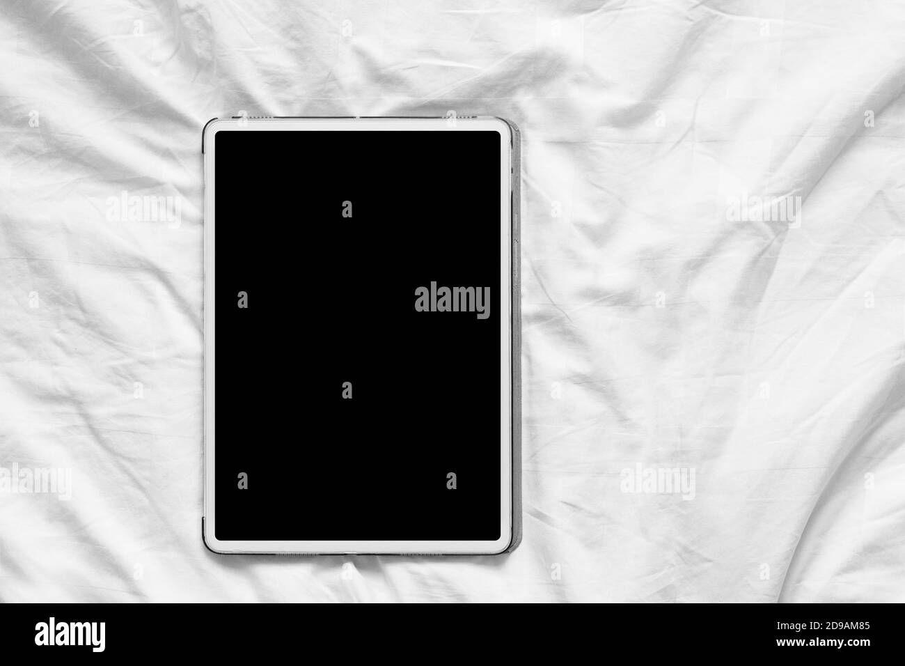 Vue de dessus maquette d'un Tablet pc blanc avec bureau vierge écran blanc sur un lit blanc confortable à la maison Banque D'Images