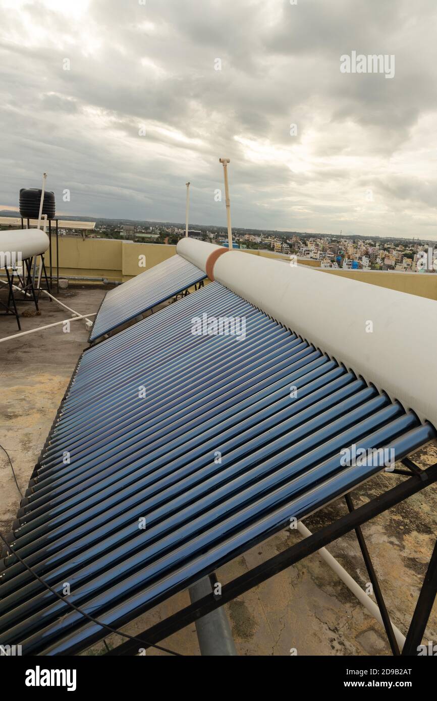 panneaux solaires et tubes installés sur les toits de maison et des plans de construction pour économiser de l'énergie pour le chauffage de l'eau Banque D'Images