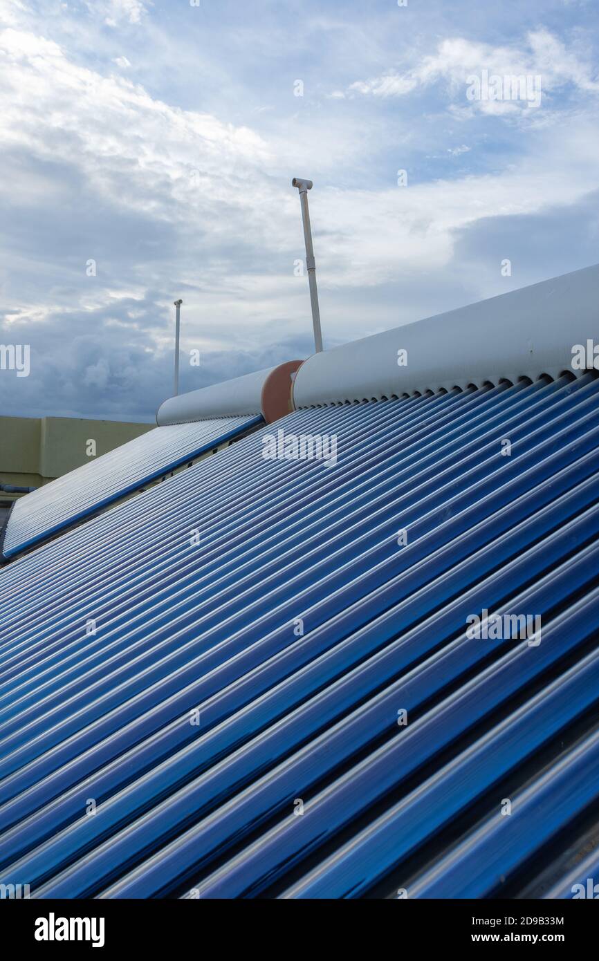 panneaux solaires et tubes installés sur les toits de maison et des plans de construction pour économiser de l'énergie pour le chauffage de l'eau Banque D'Images