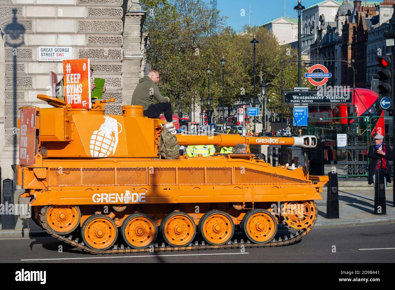 Westminster, Londres, Royaume-Uni. 4 novembre 2020. Un ancien char Abbott de l'armée britannique (plus correctement un fusil automoteur) a fait le tour de Westminster et du Parlement pour protester contre la fermeture des gymnases pendant le confinement du coronavirus COVID-19. Le véhicule blindé orange Vickers Abbot FV433 démoggé fait la publicité de Grenade, une barre de nutrition. Dans Great George Street Banque D'Images