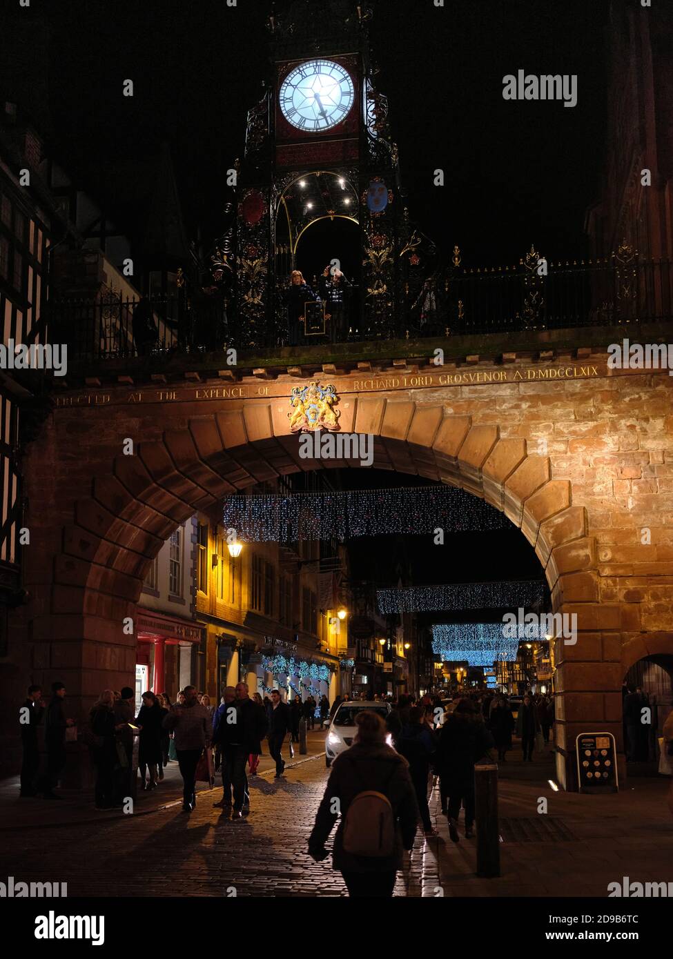 Les amateurs de Noël en fin de soirée sous l'Eastgate Clock à Chester, en Angleterre Banque D'Images