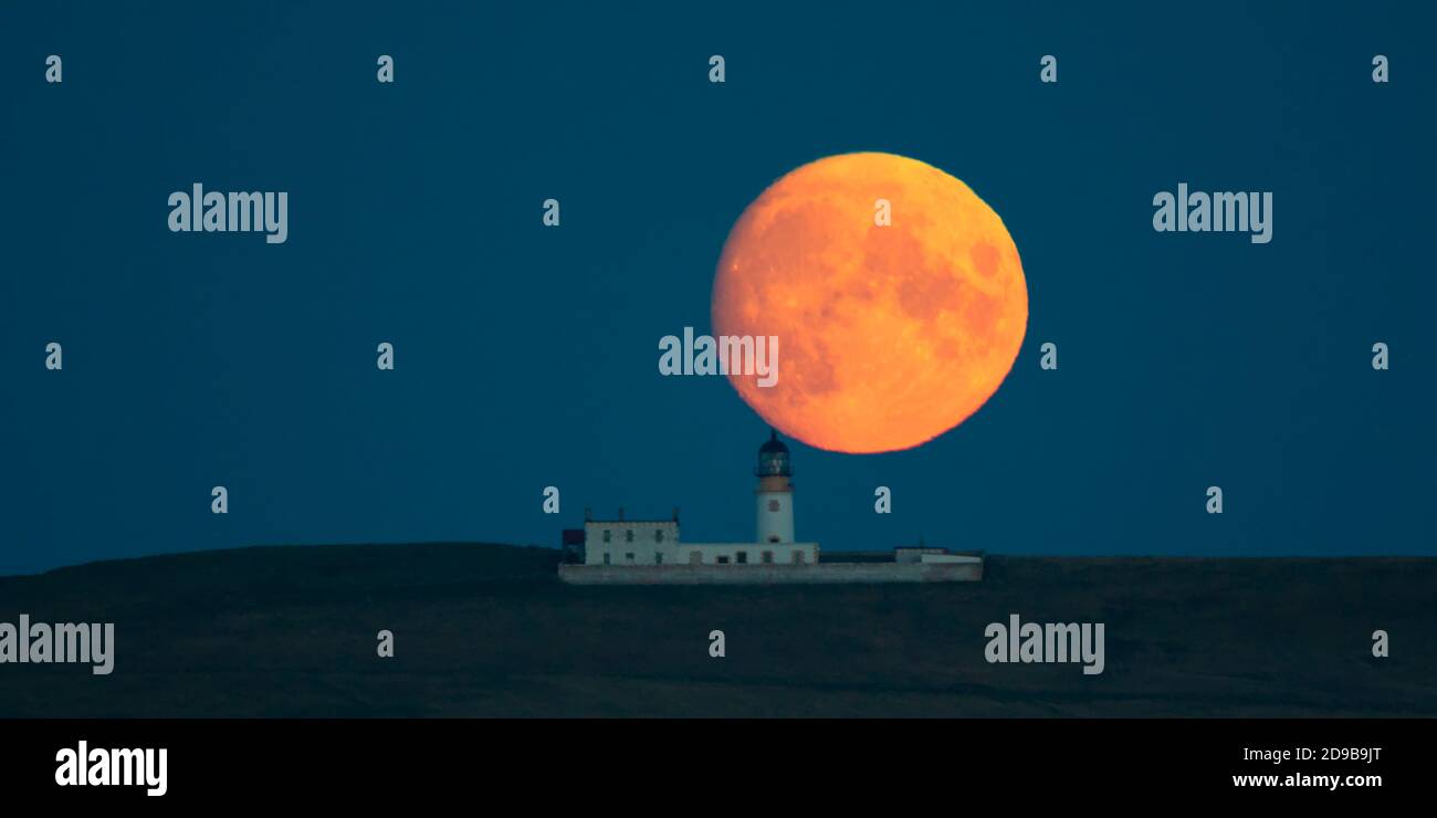 Pleine lune se levant derrière le phare de Copinsay, aux îles Orcades Banque D'Images