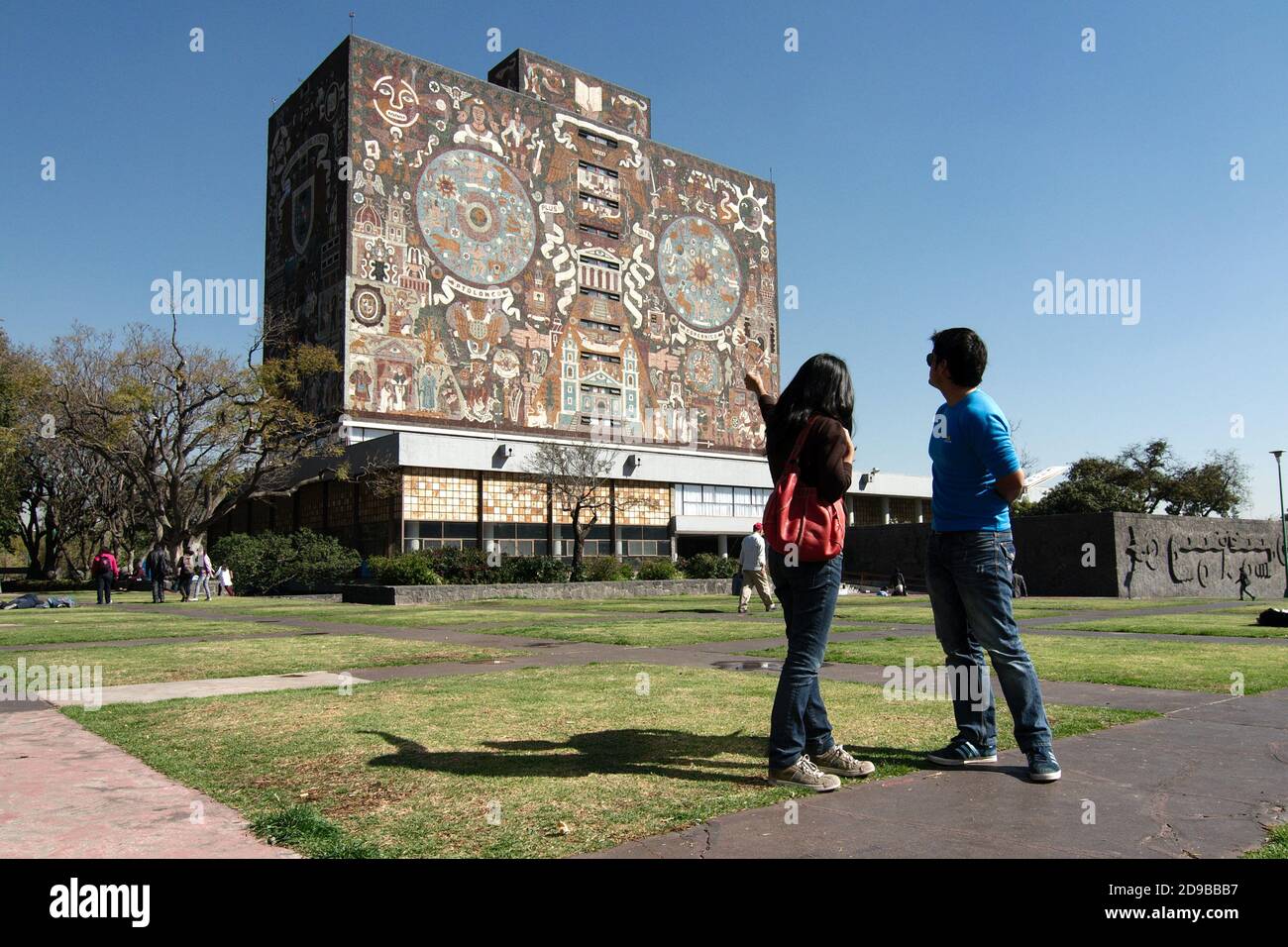 Mexico, Mexique - 2020 : les étudiants regardent le bâtiment de la bibliothèque centrale du campus de l'Université nationale autonome du Mexique, un site classé au patrimoine de l'UNESCO. Banque D'Images