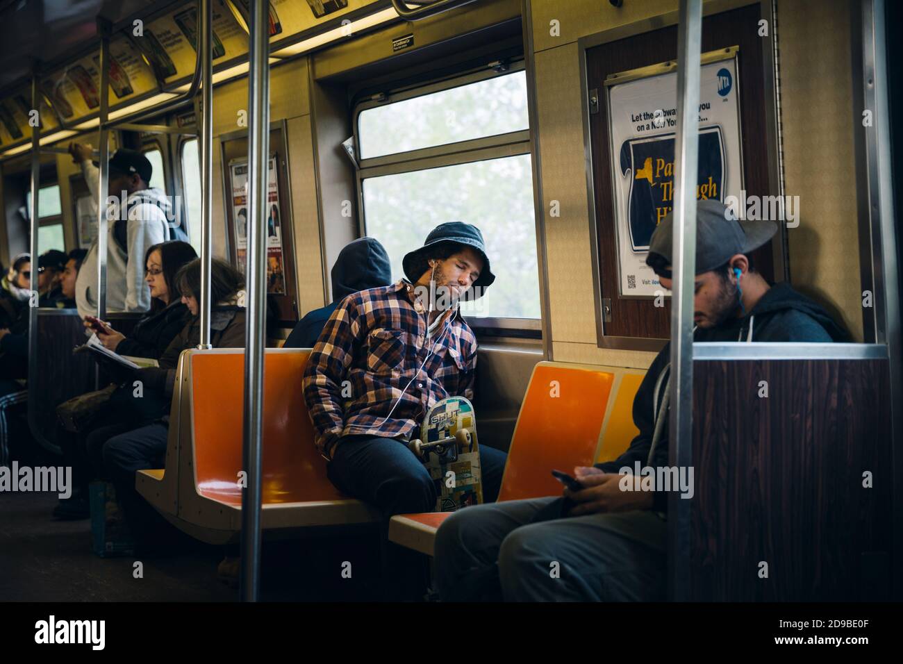 NEW YORK, États-Unis - 28 avril 2016 : les navetteurs en wagon de métro de New York. Jeune homme écoutant de la musique avec un casque. NYC Subway est l'un des plus anciens et des plus anciens Banque D'Images