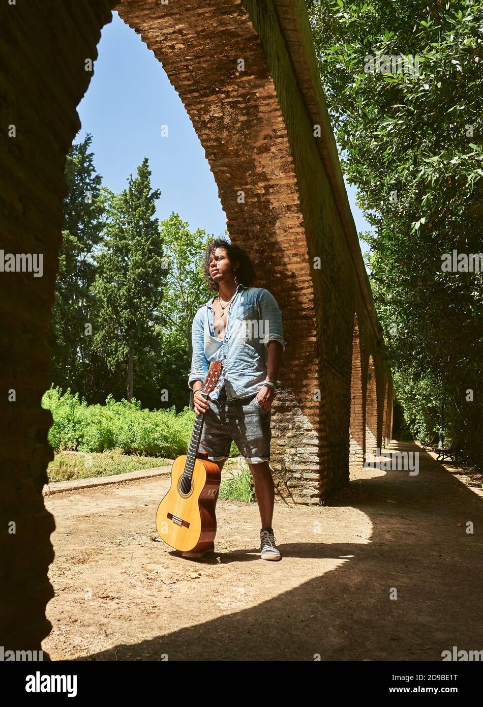 Jeune homme à la peau brune avec une guitare espagnole classique. Banque D'Images