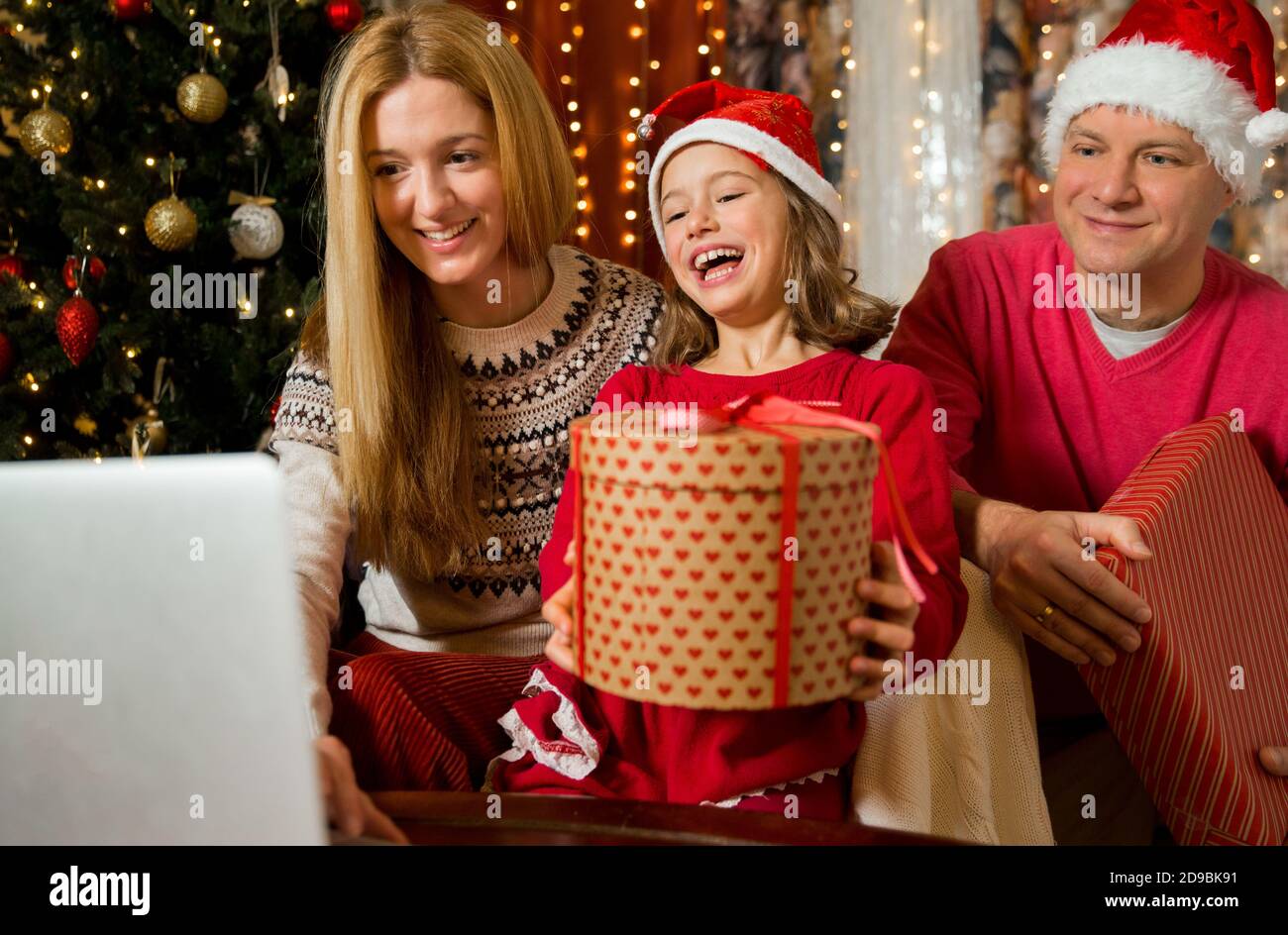 Un couple heureux avec un enfant fête Noël avec ses amis lors d'un appel  vidéo à l'aide d'une webcam. La veille de Noël, la famille accueille leurs  parents Photo Stock - Alamy