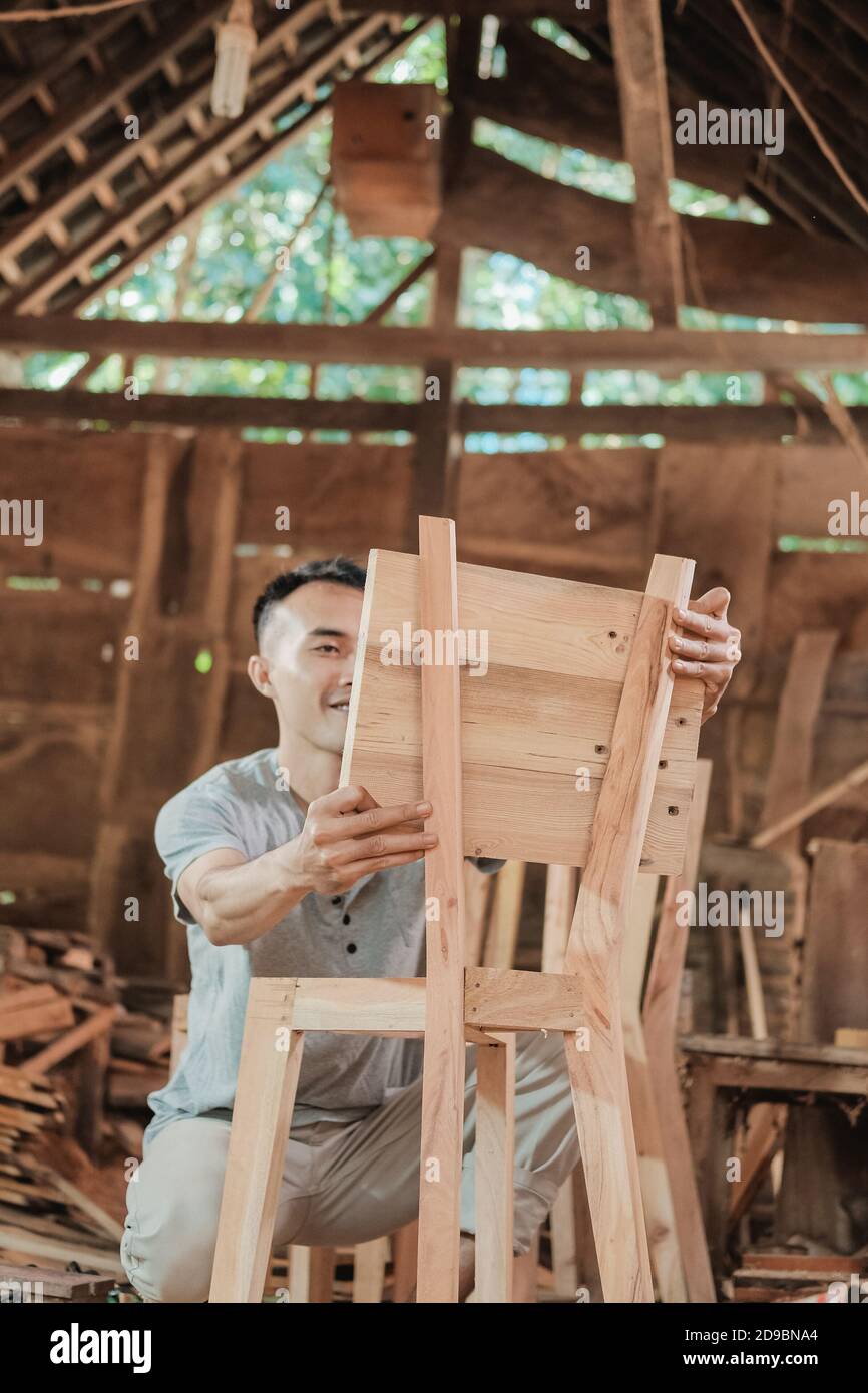 les menuisiers travaillent à la fabrication de chaises et à l'installation de dossiers de chaises en bois l'atelier Banque D'Images