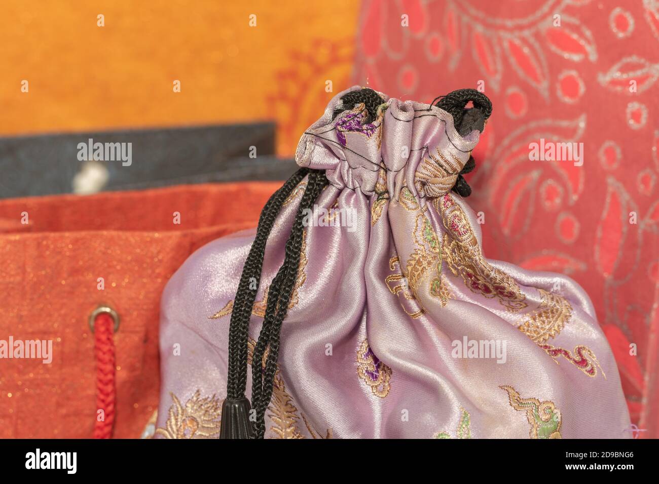 Image de mise au point sélective d'un tissu en soie Housse avec sacs de transport en papier colorés à l'arrière-plan Banque D'Images