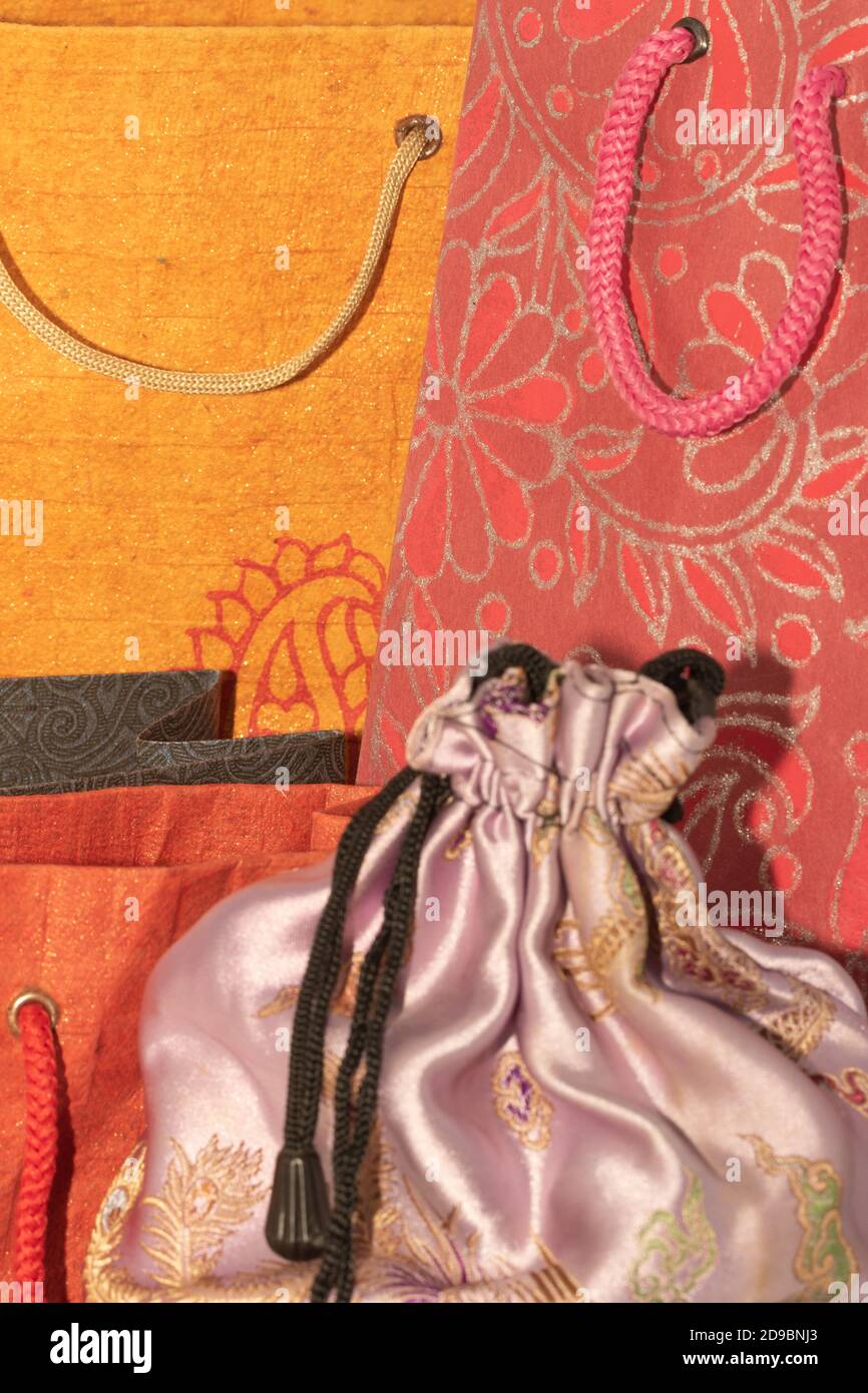 Image de mise au point sélective d'un tissu en soie Housse avec sacs de transport en papier colorés à l'arrière-plan Banque D'Images