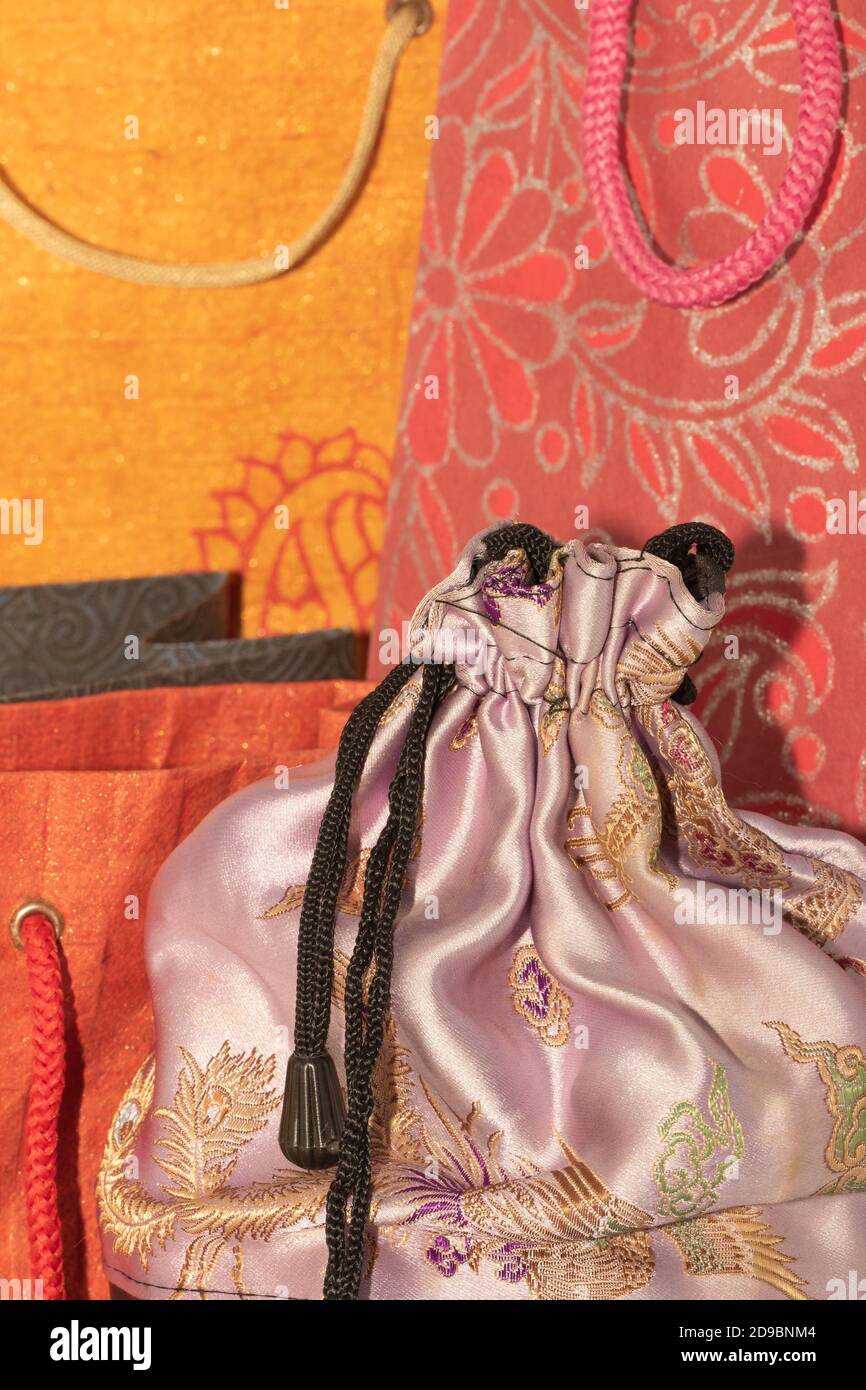 Image de mise au point sélective d'un tissu en soie Housse avec sacs de transport en papier colorés à l'arrière-plan Banque D'Images