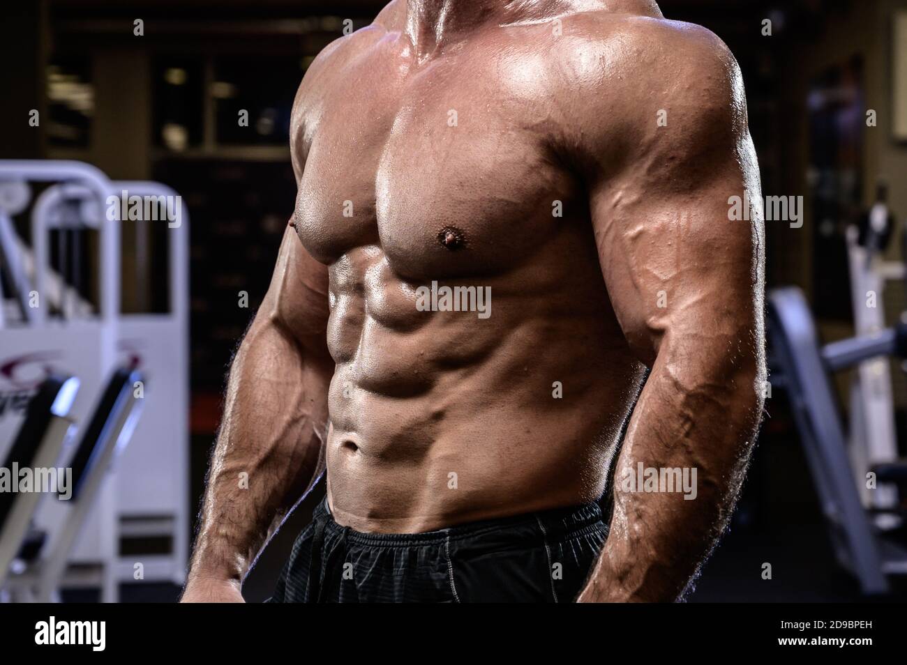 santé active activité de forme physique concept de jeune adulte homme fort corps physique oblique muscle couvert d'huile dans le sport sombre salle de sport Banque D'Images