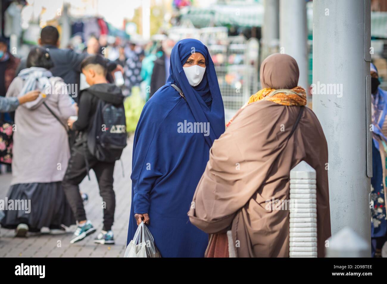 Londres, Royaume-Uni - 3 novembre 2020 - UNE femme musulmane portant un chador et un masque facial lors de ses achats sur le marché de Walthamstow Banque D'Images