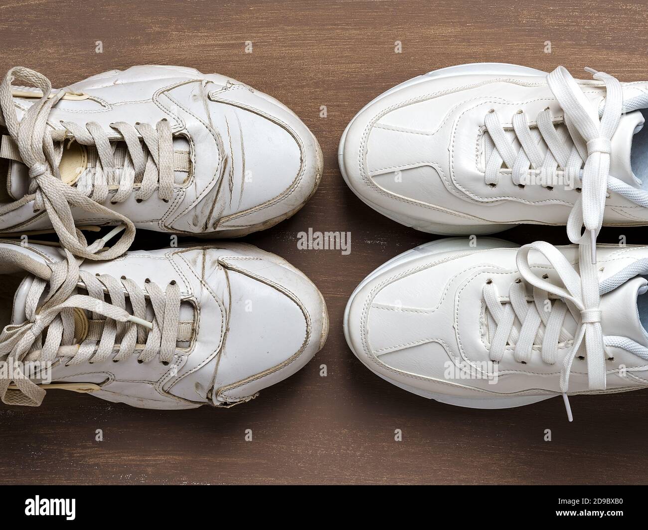 Paire de sneakers blanches sales anciennes devant la nouvelle, sur fond marron. Passé et futur, vieux et nouveaux concepts. Vue de dessus. Banque D'Images