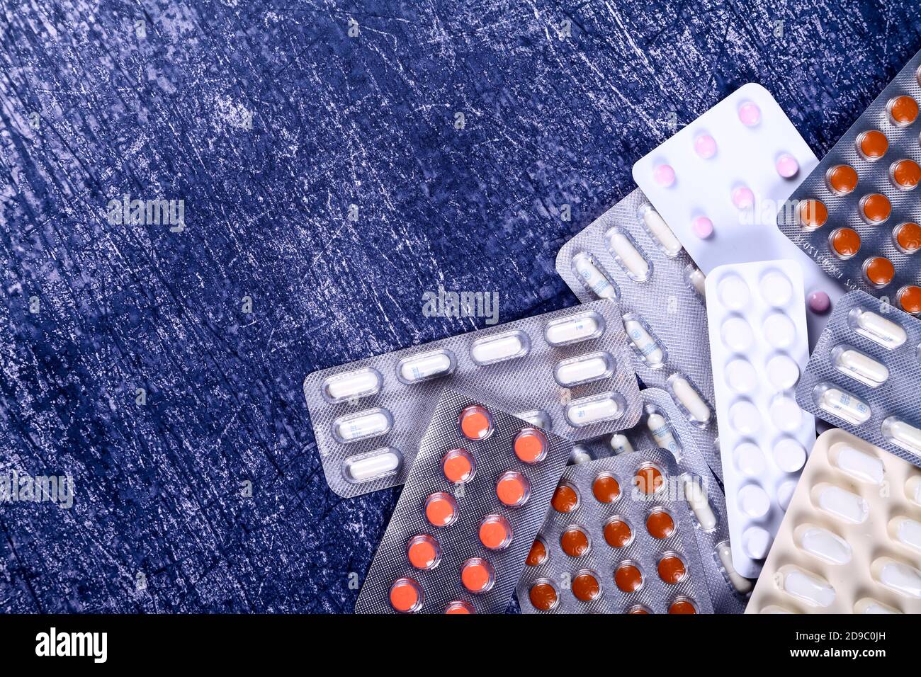 Collection de médicaments d'ordonnance en plaquettes thermoformées sur un bleu arrière-plan texturé Banque D'Images
