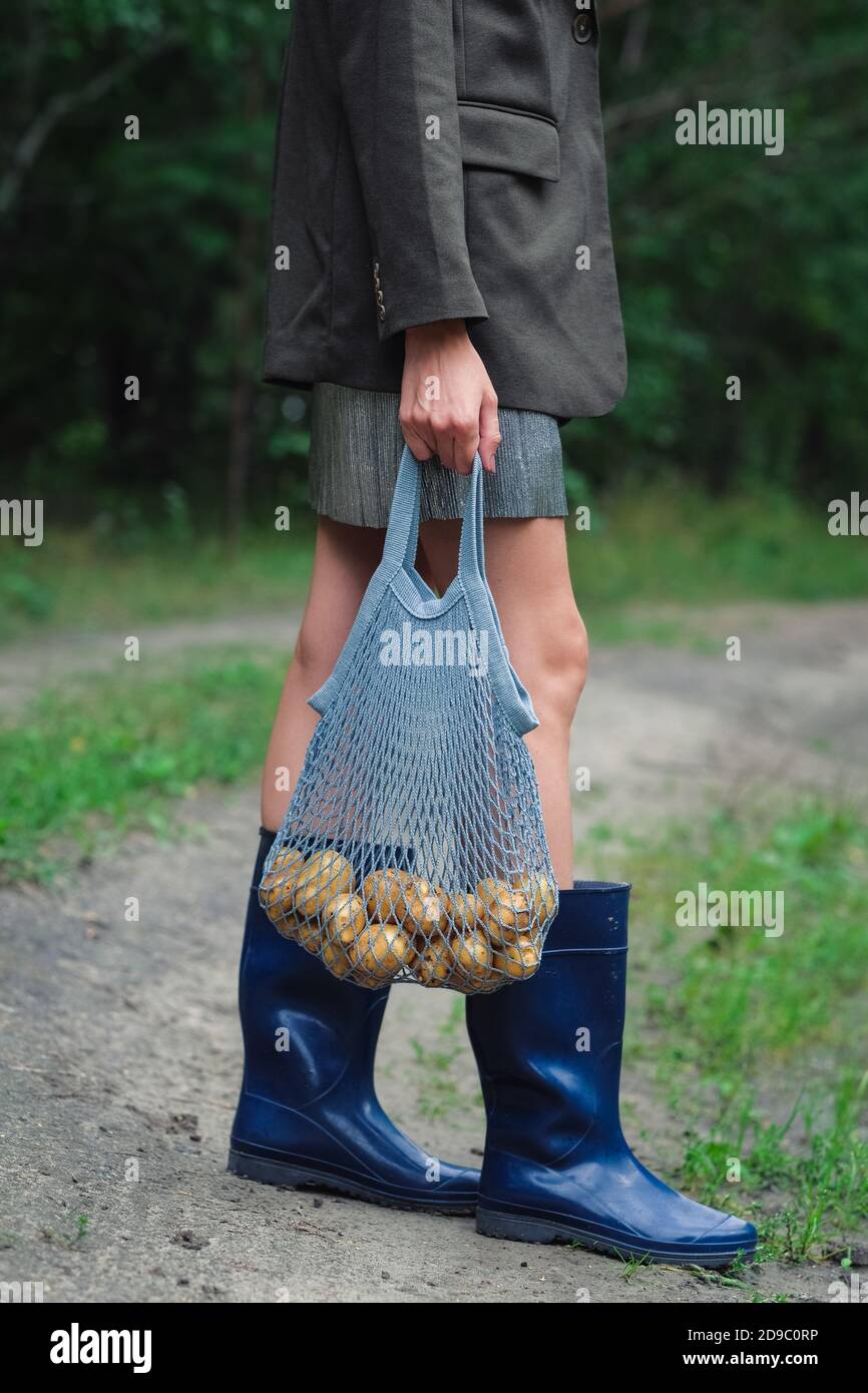 Femme tenant un sac de ficelle avec des pommes de terre. Banque D'Images
