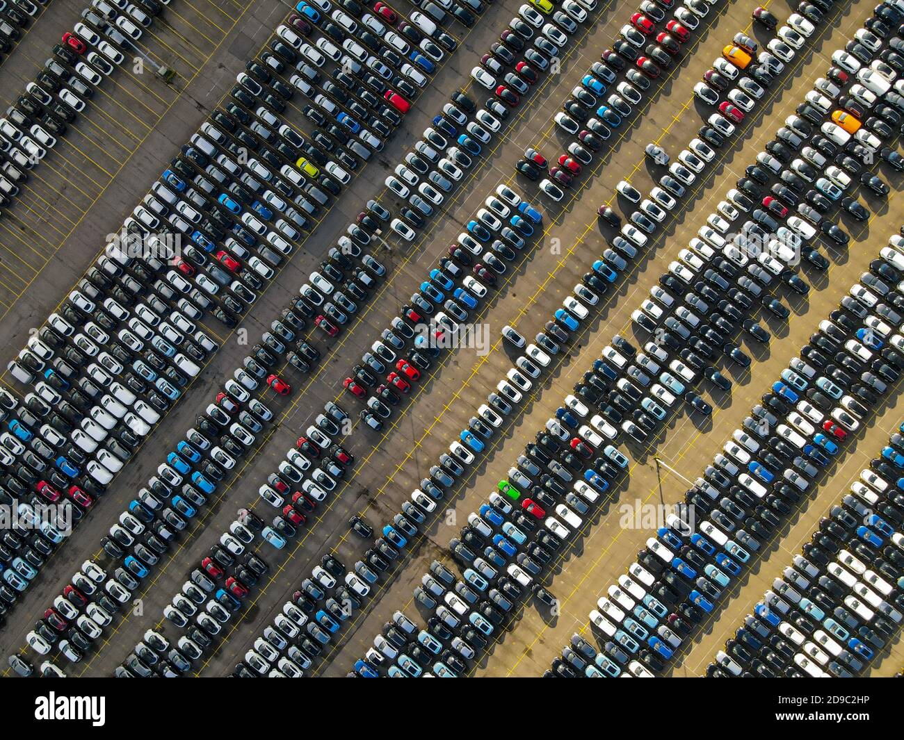 Photo aérienne de voitures garées dans une rangée structurée de stationnement voitures de location nouvelle industrie de production Banque D'Images