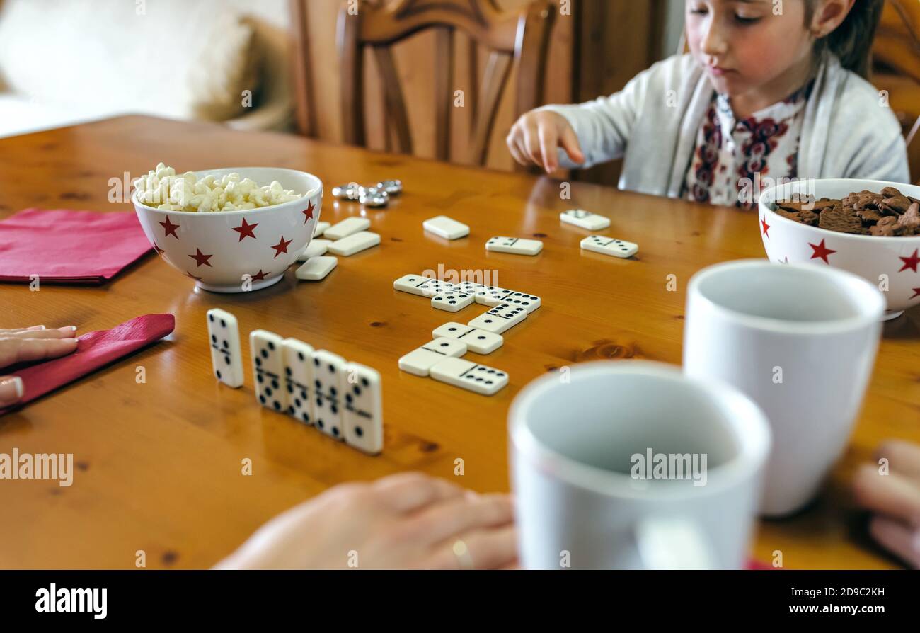 Fille jouant à domino avec sa famille Banque D'Images