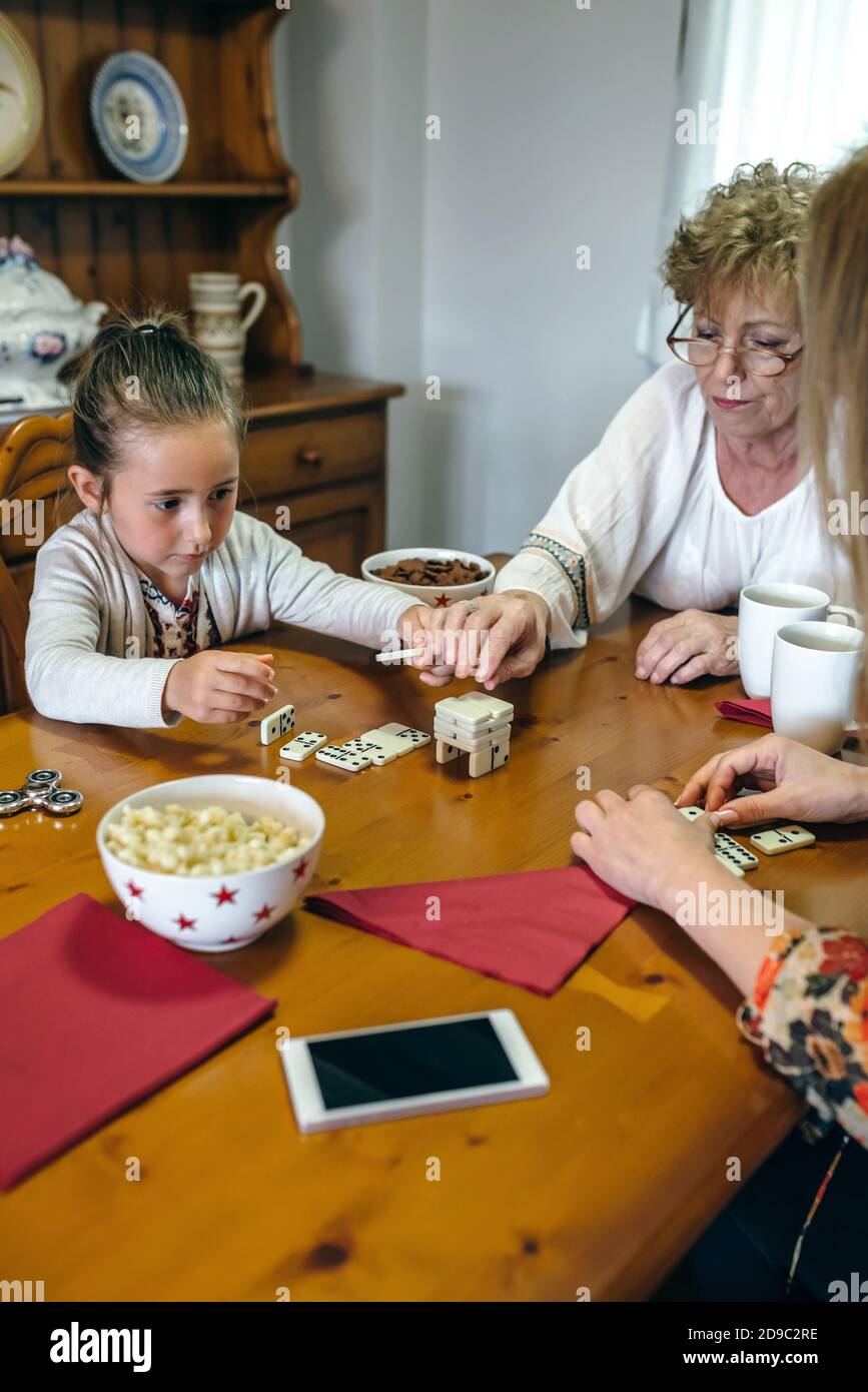 Trois générations de femmes jouant avec des dominos Banque D'Images