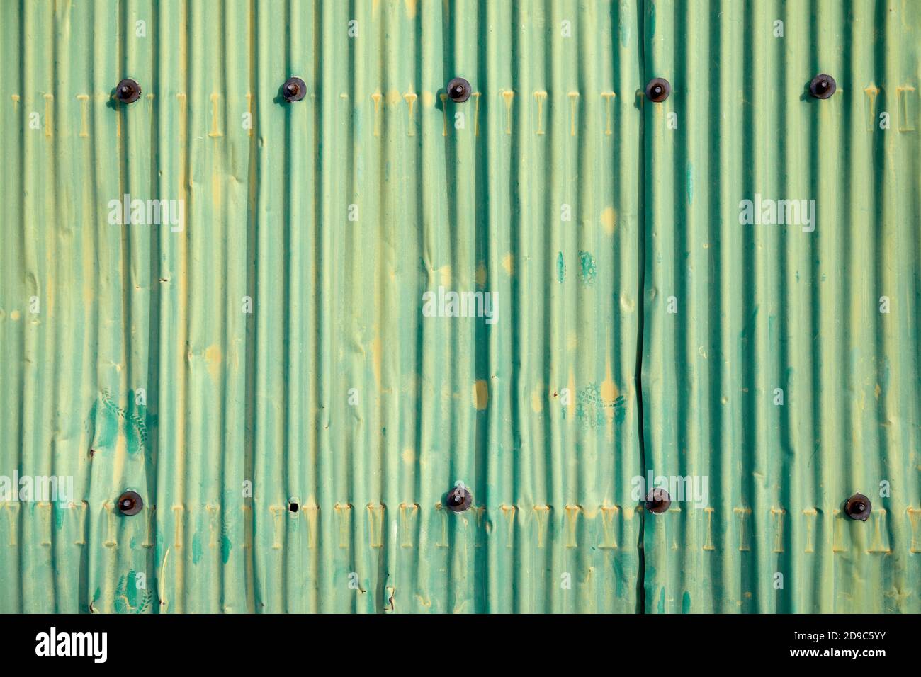 Paroi en métal ondulé avec peinture vert jaunâtre décolorée Banque D'Images Paroi en métal ondulé avec peinture vert jaunâtre décolorée Banque D'Images