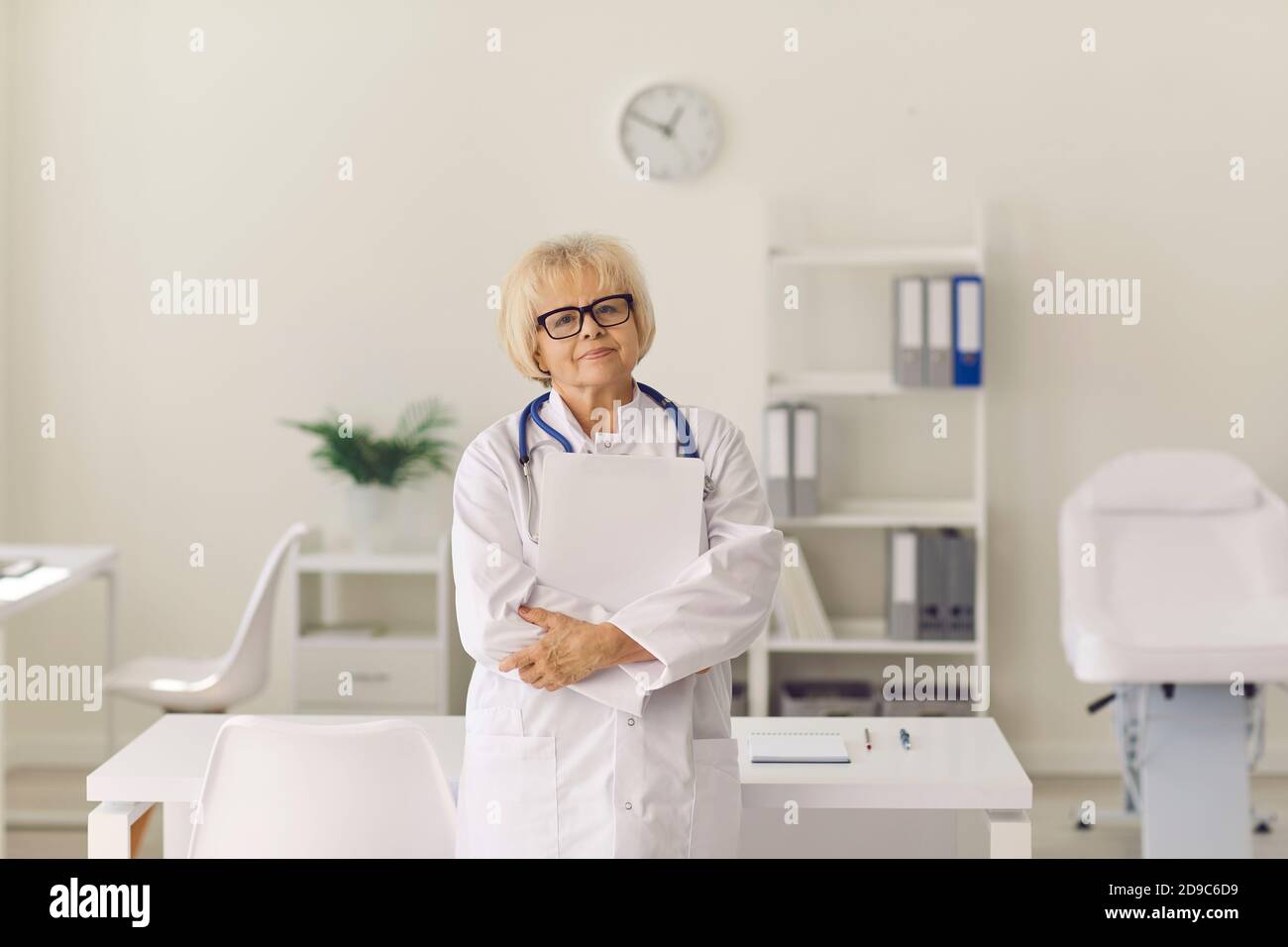 Portrait d'un médecin expérimenté regardant l'appareil photo debout bureau de l'hôpital Banque D'Images