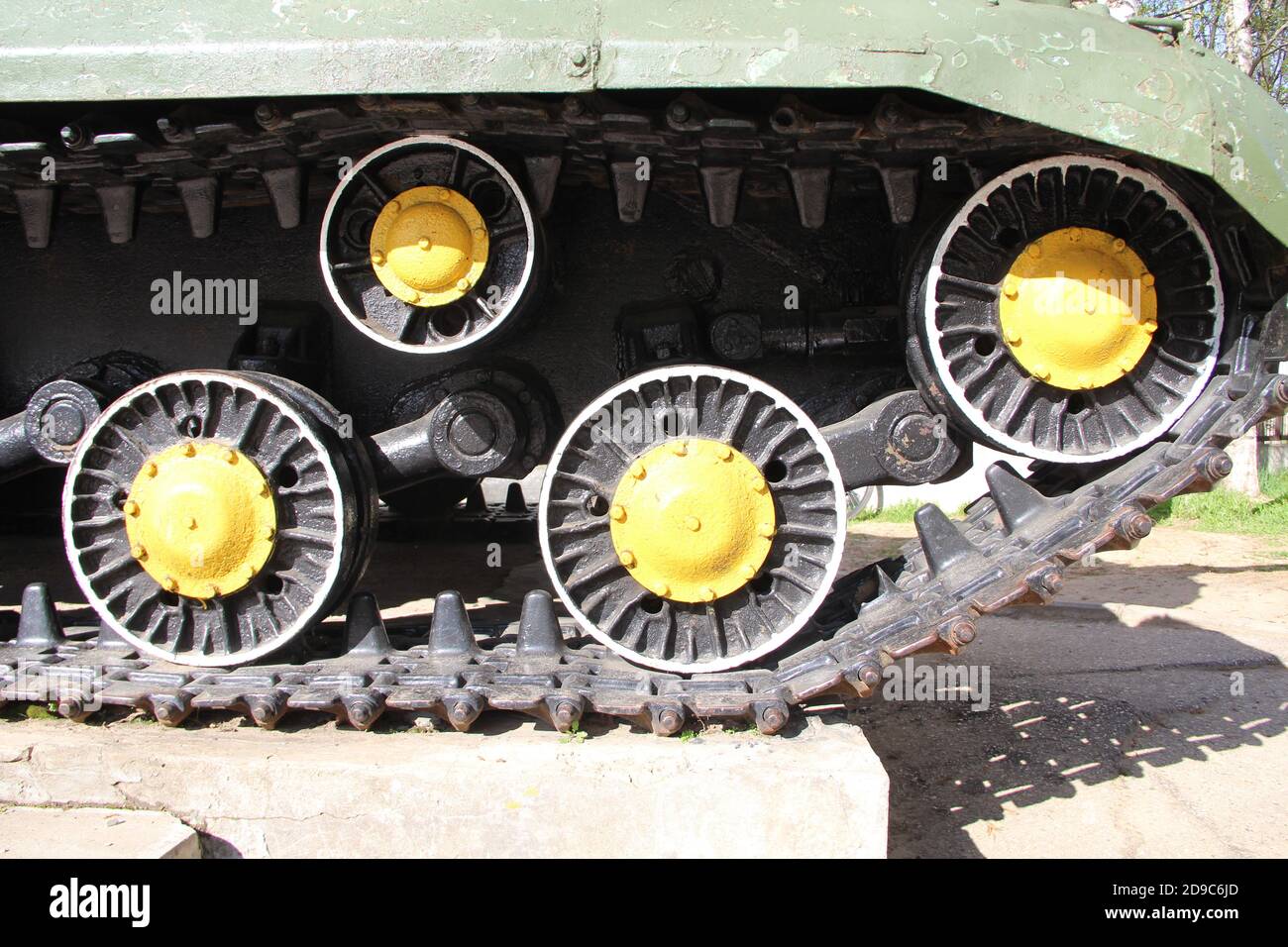 Caterpillar et les rouleaux du réservoir russe SU-152, vue de côté. Fragment du châssis du véhicule blindé militaire du système soviétique d'artillerie automotrice. Les patinoires sont peintes en jaune et en noir. La couleur de l'armure est verte. Banque D'Images
