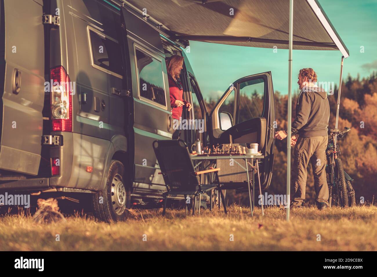 Couple caucasien et leur week-end de escapade. Campeur Van Camping-car amarré à un endroit éloigné pendant le paysage d'automne. Thème RVing de classe B. Banque D'Images