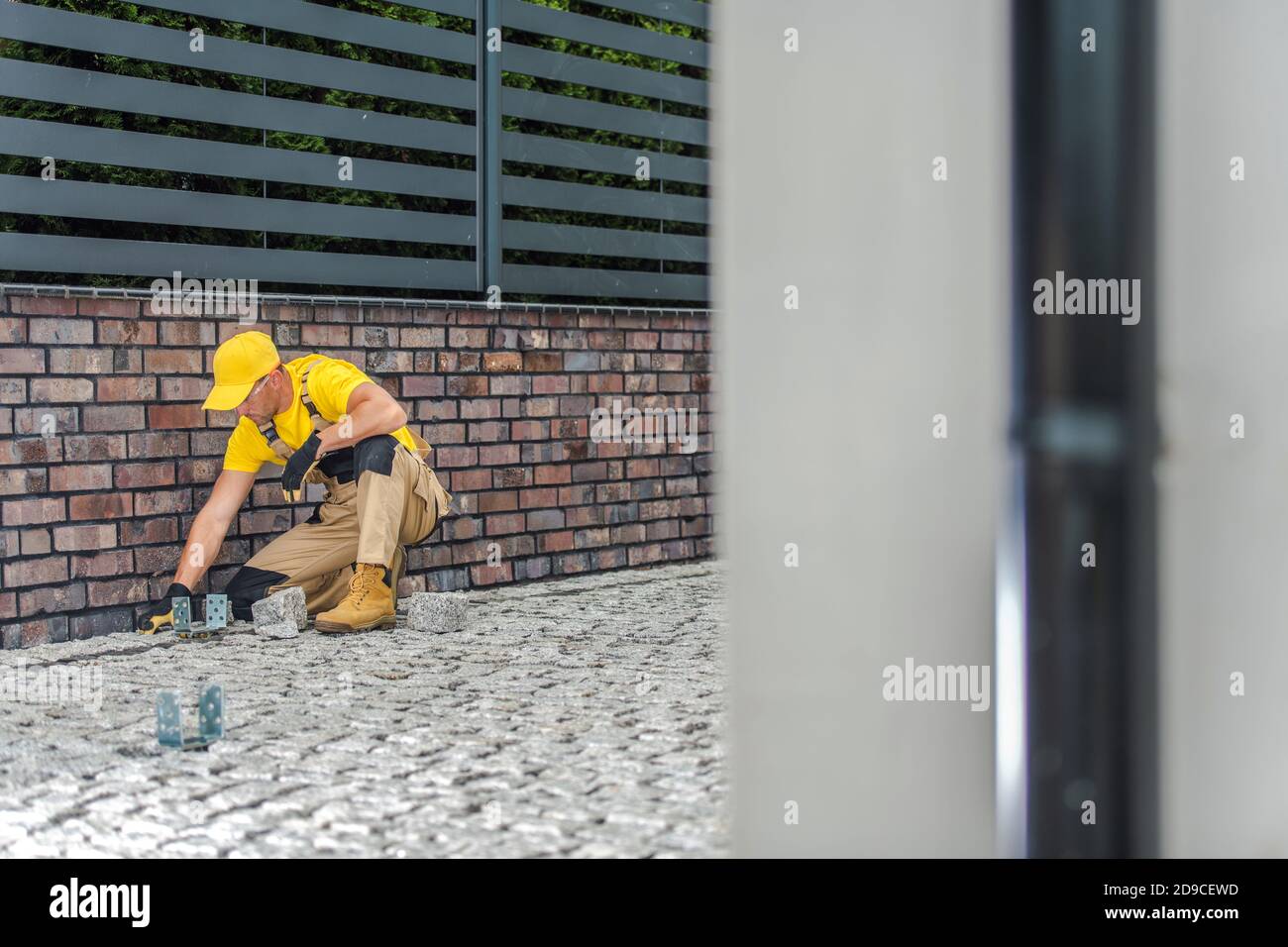 Caucasien ouvrier de construction finition résidentielle allée Granite chaussée. Thème de l'industrie de la construction. Banque D'Images