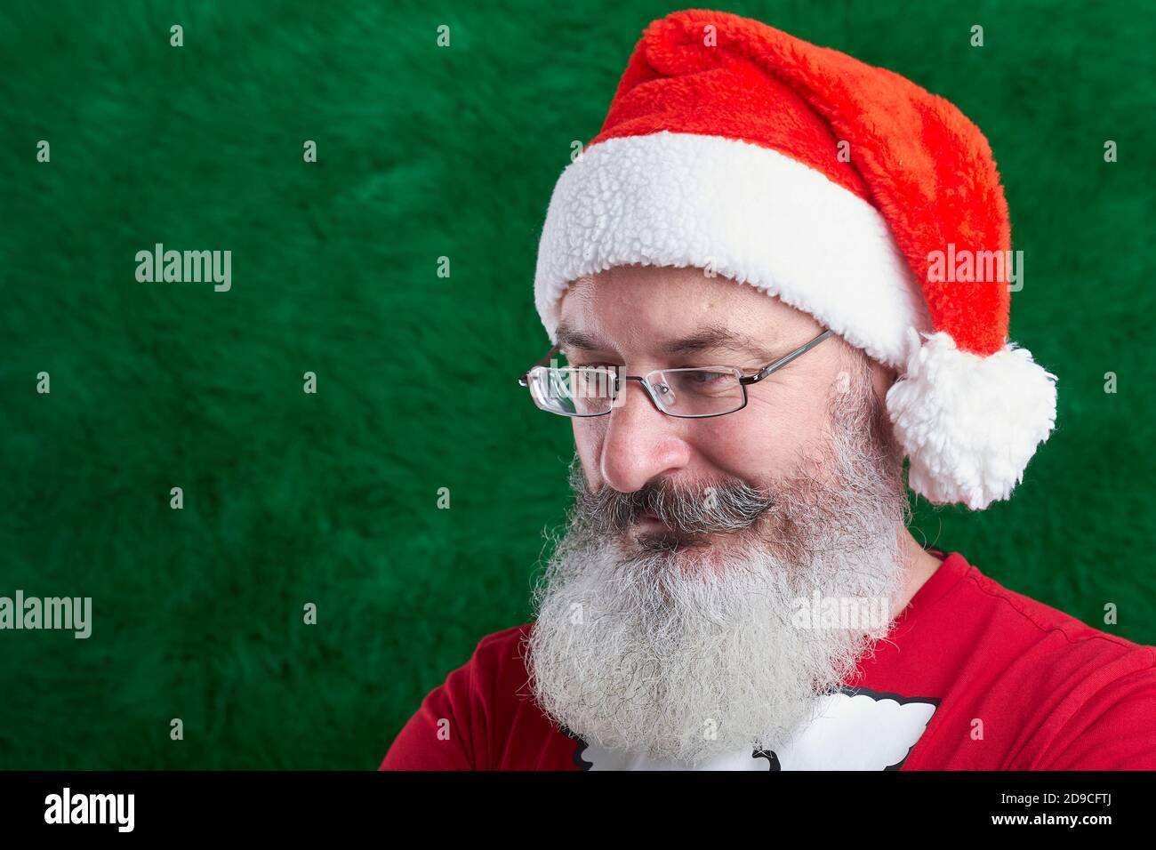 Homme à barbe mature avec lunettes sur son visage portant un chapeau de  père Noël, arrière-plan artificiel d'arbre de Noël, espace de copie Photo  Stock - Alamy