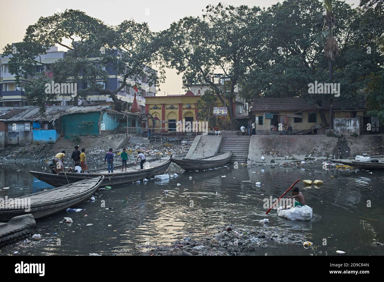 Kolkata, Inde, janvier 2008. Personnes traversant un canal fortement pollué dans un bidonville de Kalighat avec un pont de bateau. Banque D'Images