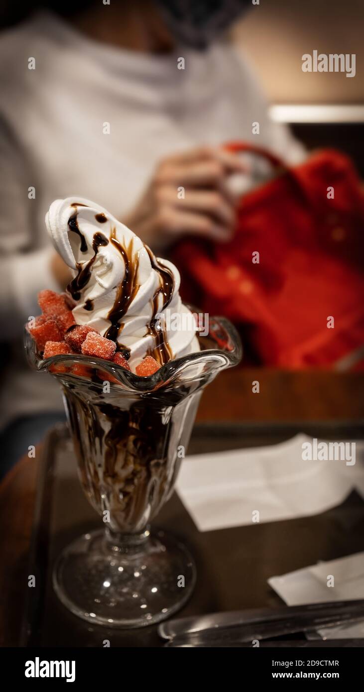 Un délicieux dessert de sundae au chocolat avec des tranches de fraises congelées. Banque D'Images