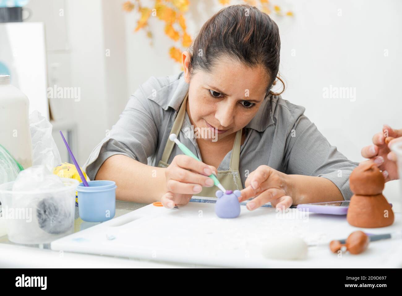 Femme hispanique travaillant dans sa pâtisserie - Latina femme travailler avec fondant pour décorer un gâteau - pâtisserie entrepreneur chef - femme faisant l'artisanat avec Banque D'Images
