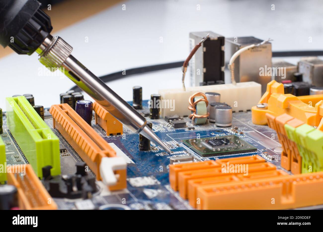 Utilisez un fer à souder pour souder la pièce électronique sur la carte. Réparation de l'ordinateur. Macrophotographie. Banque D'Images
