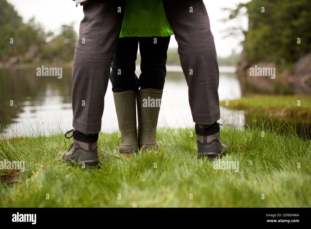 Portrait depuis l'arrière des jambes avec des bottes debout au bord du lac Banque D'Images