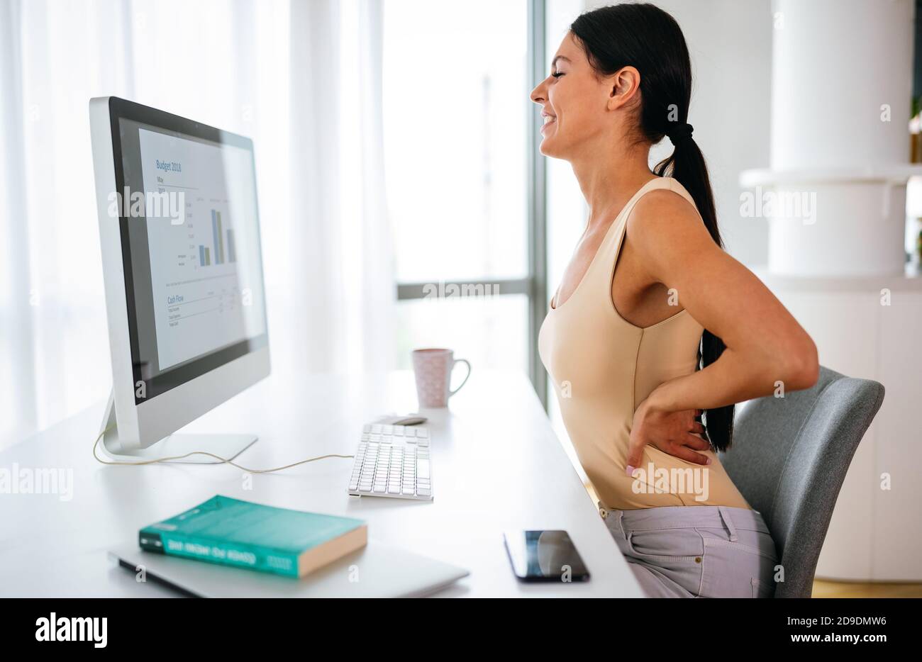 Femme surchargés d'une douleur dans la région de bureau avec une mauvaise posture Banque D'Images