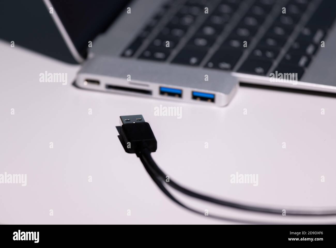 la photo super macro mise au point sur un câble usb a noir, un adaptateur usb vers usb-c et un ordinateur portable ne sont pas très bien mis au point Banque D'Images