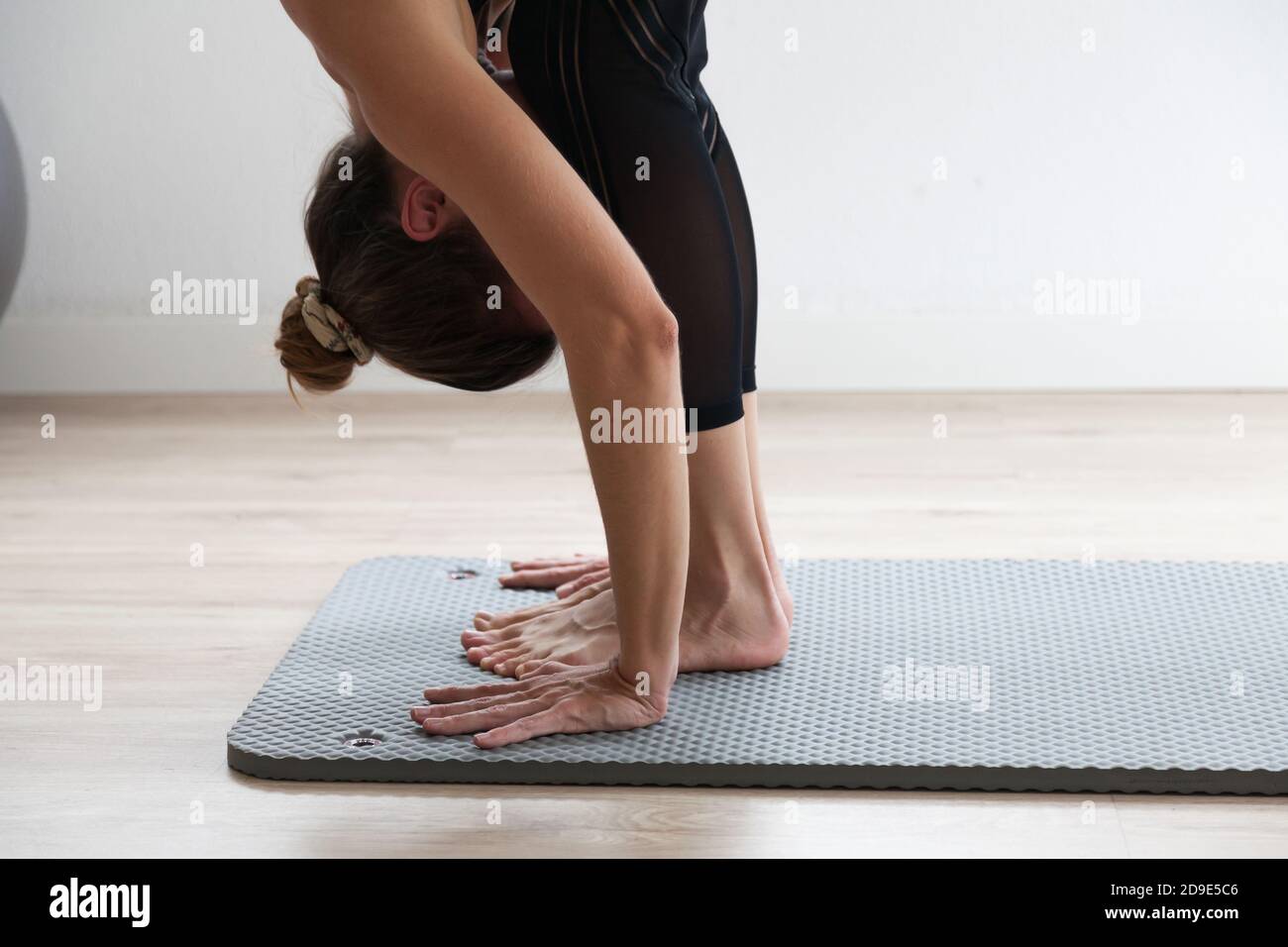 femme méconnue pratiquant le yoga sur un tapis de yoga Banque D'Images