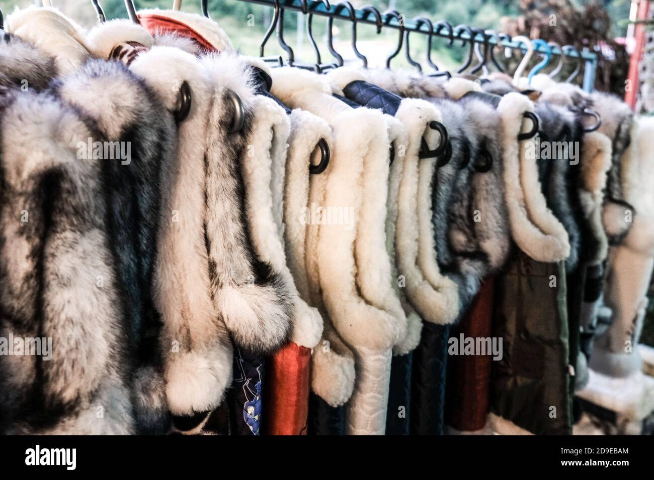 Un tas de gilets de fourrure traditionnels ukrainiens suspendus pour la vente dans un magasin extérieur dans un village rural en Ukraine. Artisanat fait à la main sur une foire locale. Banque D'Images