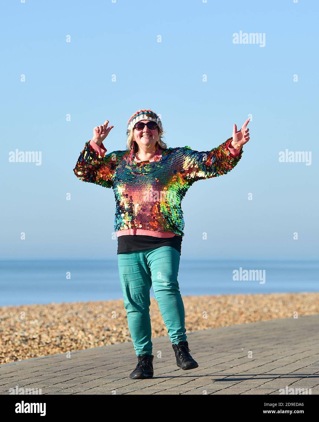 Brighton Royaume-Uni 5 novembre 2020 - Cara Mathia Brennan connu sous le nom de Cara Sparkles danse le long de Brighton front de mer dans un beau soleil le premier jour des nouvelles restrictions de blocage du coronavirus en Angleterre comme temps plus ensoleillé est prévu pour les prochains jours . Cara va danser chaque jour à travers le nouveau verrouillage comme elle l'a fait pour le premier verrouillage plus tôt cette année : crédit Simon Dack / Alamy Live News Banque D'Images