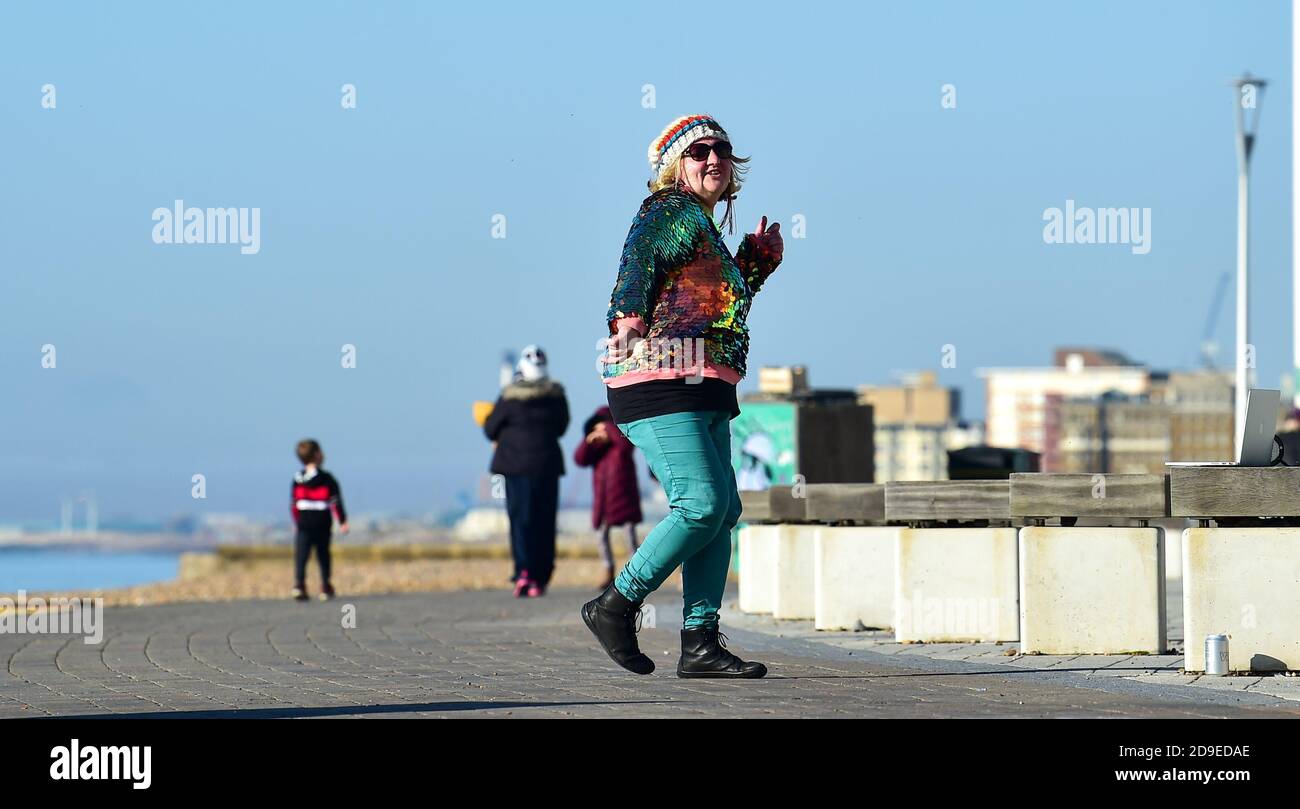 Brighton Royaume-Uni 5 novembre 2020 - Cara Mathia Brennan connu sous le nom de Cara Sparkles danse le long de Brighton front de mer dans un beau soleil le premier jour des nouvelles restrictions de blocage du coronavirus en Angleterre comme temps plus ensoleillé est prévu pour les prochains jours . Cara va danser chaque jour à travers le nouveau verrouillage comme elle l'a fait pour le premier verrouillage plus tôt cette année : crédit Simon Dack / Alamy Live News Banque D'Images