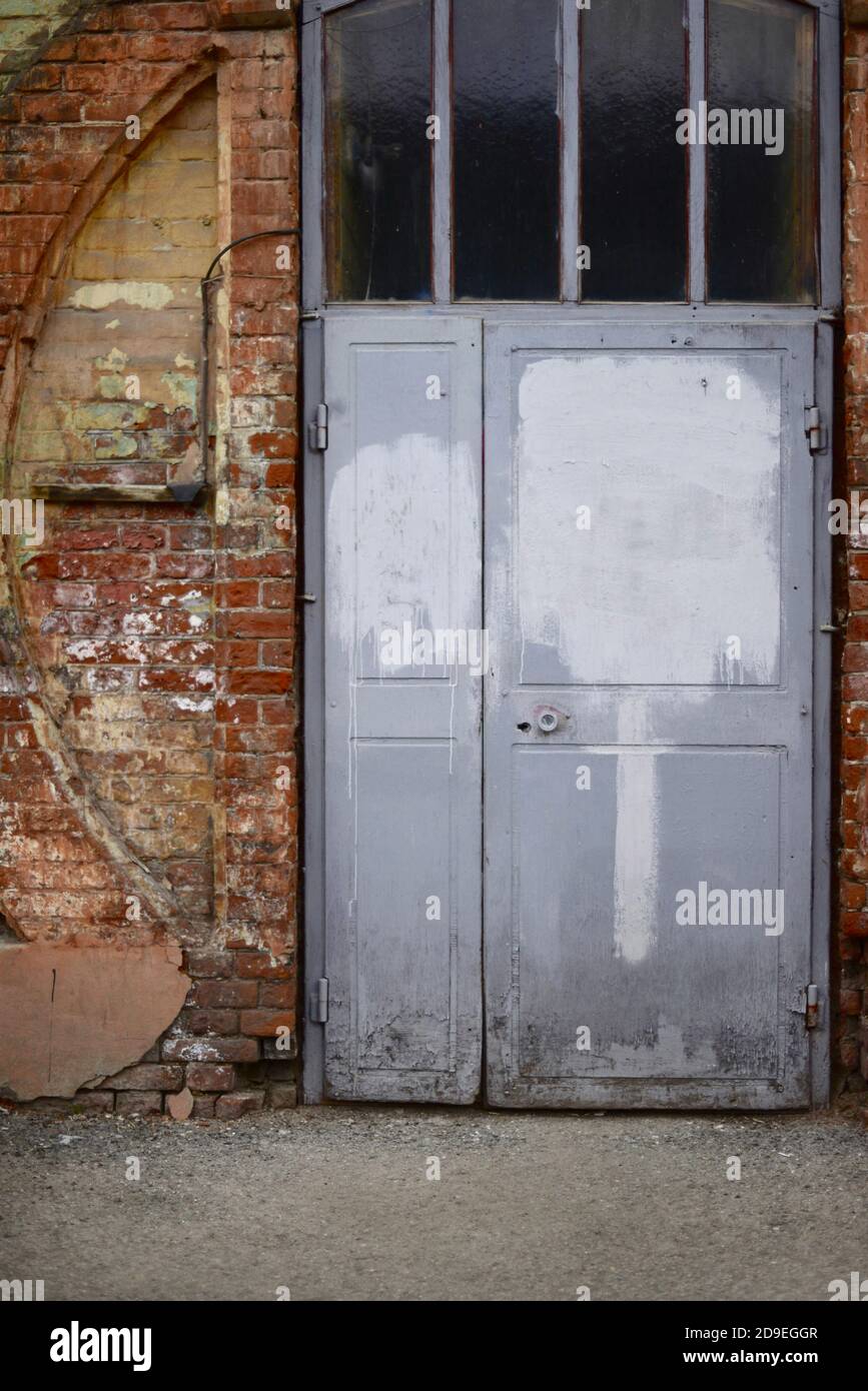 L'ancienne porte. Porte grise dans une maison en brique. Banque D'Images