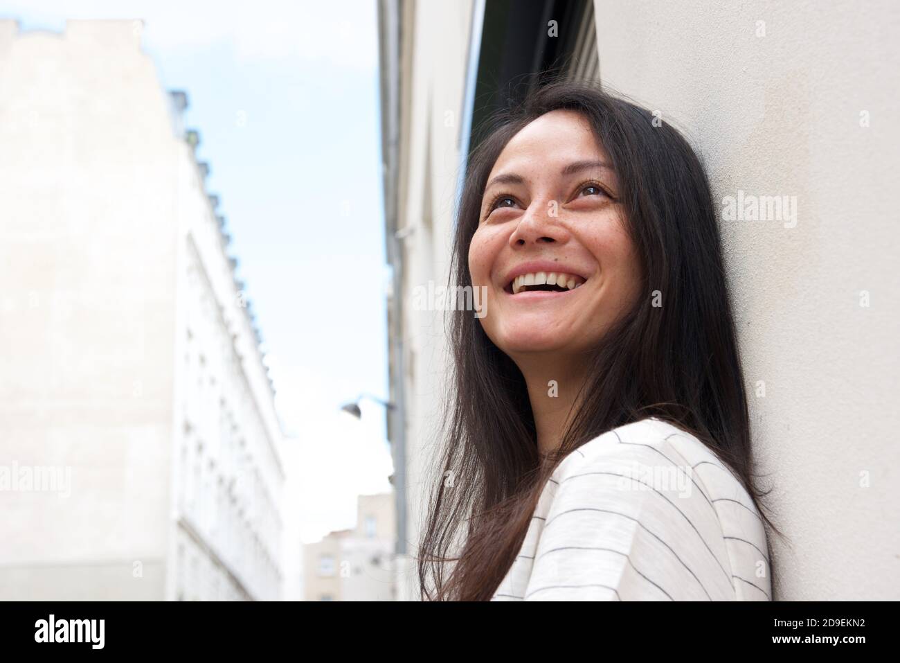 Gros plan sur le côté bonne jeune femme asiatique penchée contre mur extérieur Banque D'Images