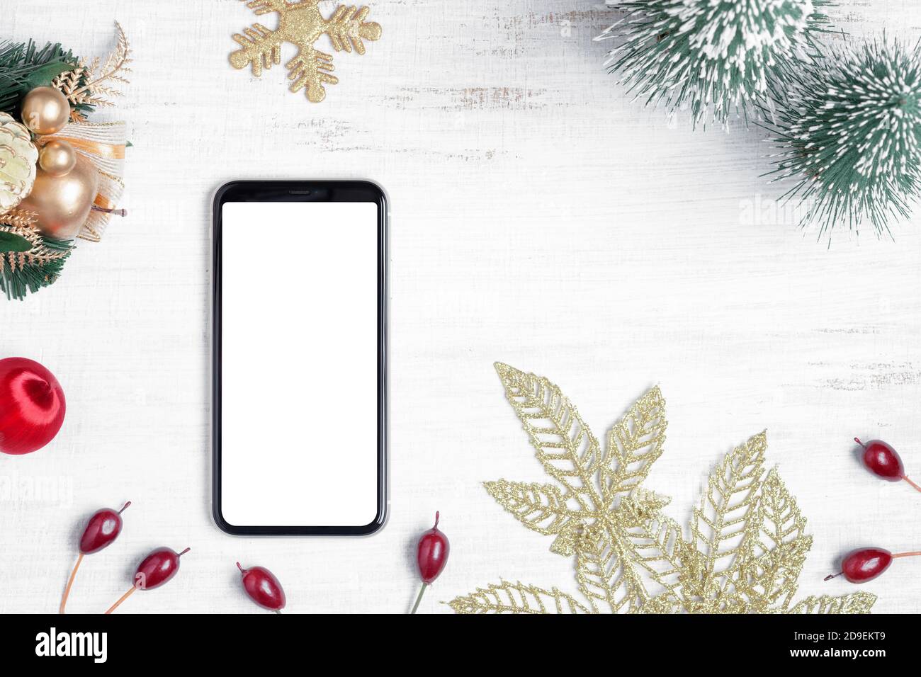 Maquette d'un smartphone blanc sur fond de bois blanc pour Noël et le nouvel an, vue de dessus avec plan de pose plat et espace de copie pour votre Banque D'Images