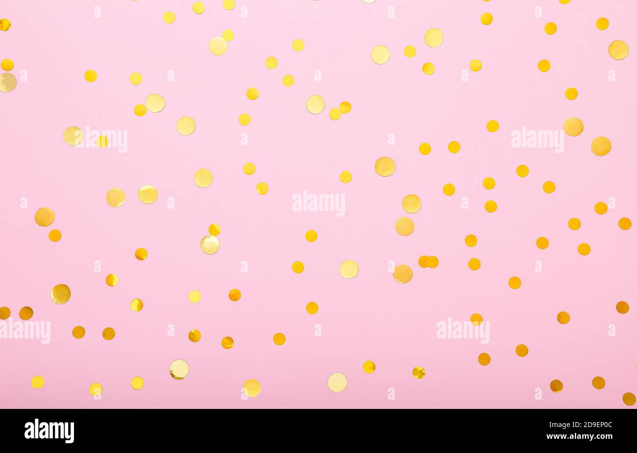 Des confettis dorés sur fond rose. Flat lay, vue de dessus, toile de fond festive. Concept de célébration. Banque D'Images