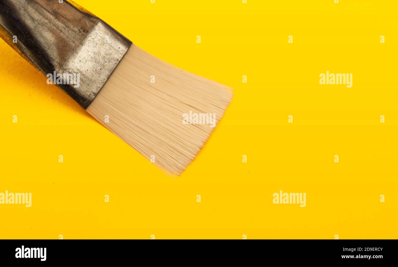Vue en gros plan du pinceau sur la surface en carton jaune Banque D'Images
