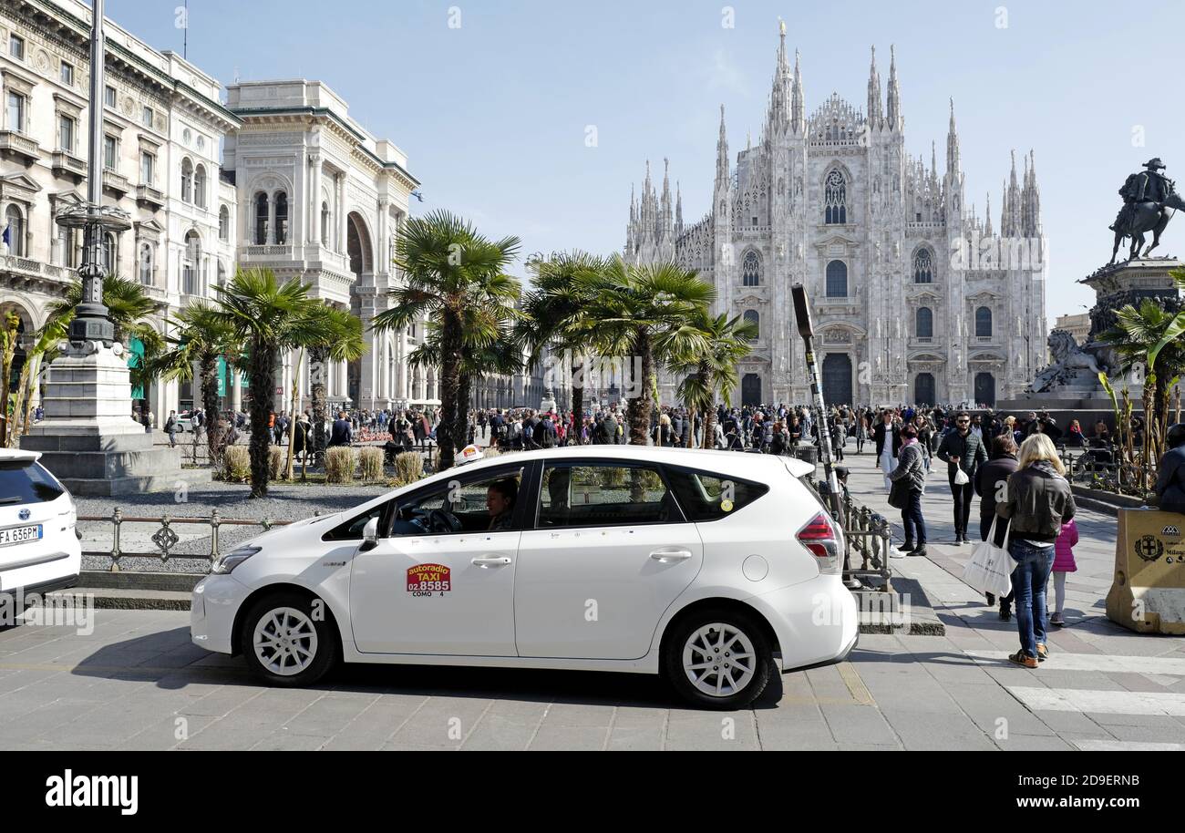 Taxi blanc sur la place Duomo de Milan. Banque D'Images