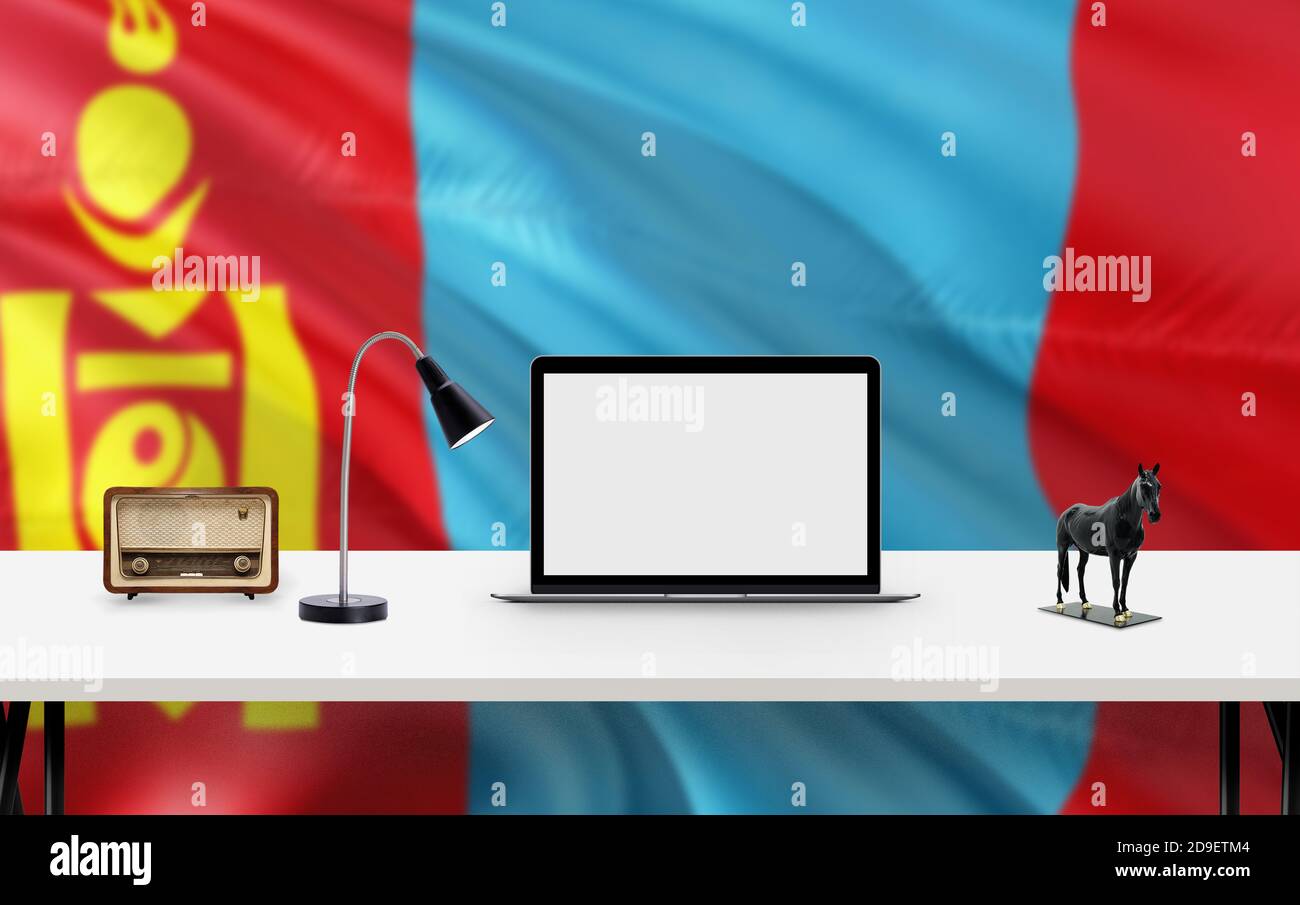 Drapeau national de Mongolie avec espace de travail, ordinateur de bureau et accessoires de bureau sur table blanche moderne. Banque D'Images